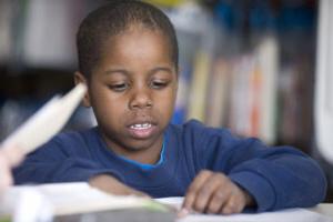 little boy reading in Reading Corps